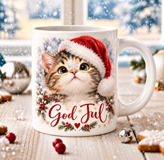 Vit julmugg med kattunge i röd tomteluva, snöflingor, grankvistar och texten God Jul – DalaStil